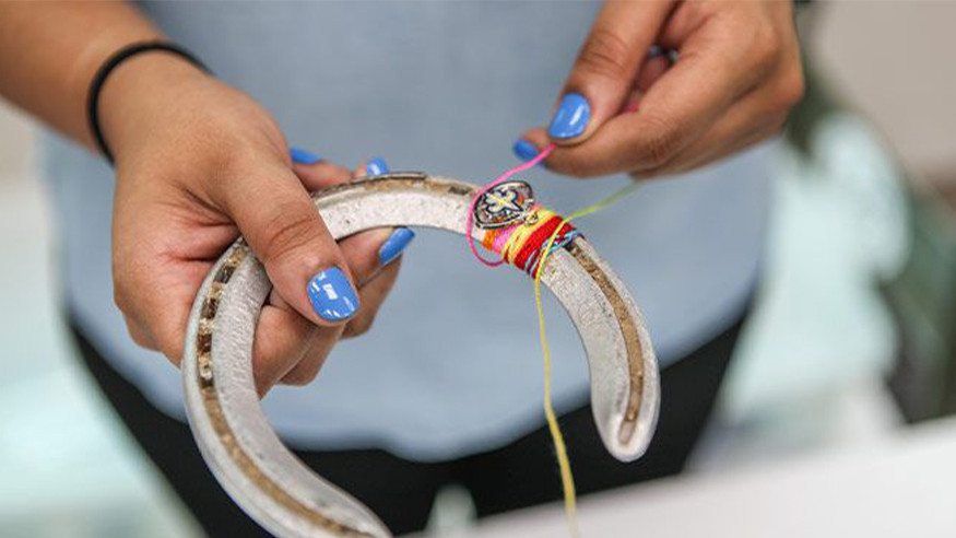 person wrapping string around horseshoe