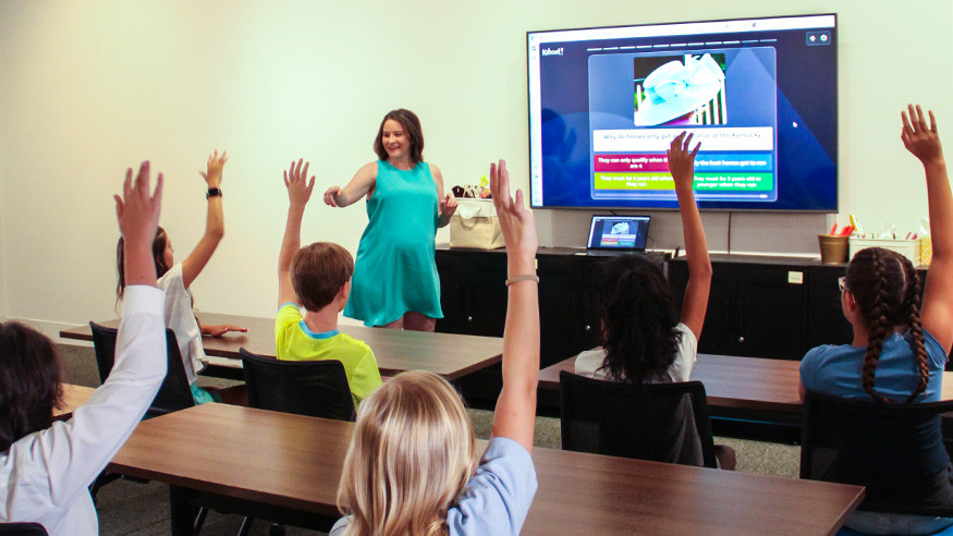 teacher leading virtual field trip programming as students raise their hands