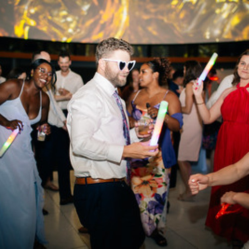 a reception being held in the great hall with party goers dancing