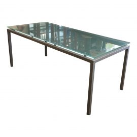 A Design Within Reach Dining Table With a Frosted Glass Top and Metal Base