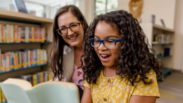 teacher and student reading a book