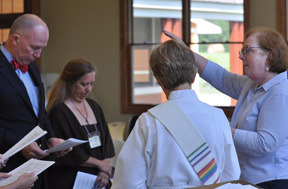 Canon Joan Smith blesses School of Ministry graduates. Pictured are Gary England and Laurie Joyce