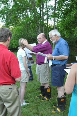 Bishop White blesses an Ascension member by the creekside 