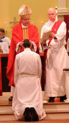 Bishop White lays hands on his newest deacon, Ben Badgett