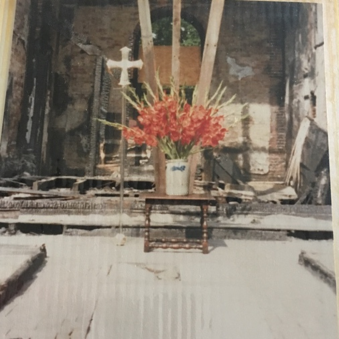 A picture of the church after the fire with flowers at a makeshift altar