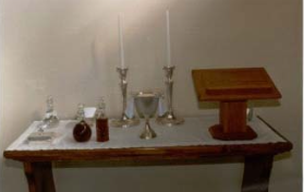 Communion silver and candlesticks displayed on a table.
