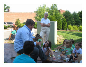 Eric Swisher, owner of Five Turkeys Farm in Shelby County, holds a baby lamb as he speaks with children at Vacation Bible camp
