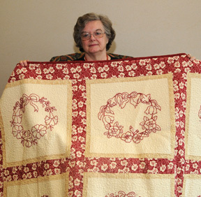 Colleen Wilson holds up wreath quilt won during benefit at Episcopal Church Home