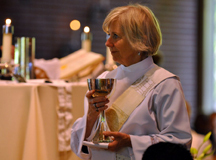 Newly ordained deacon Mary Abrams serves chalice during Eucharist