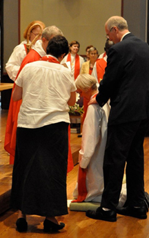 The Rev. Suzanne Warner is vested by her son.