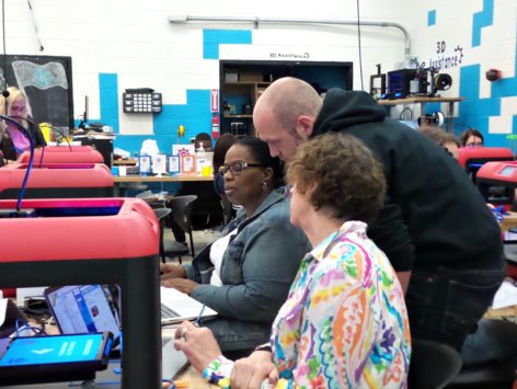 educators working with 3d printer at table with facilitator