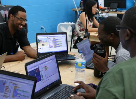 educators using Scratch to create games at a table during DHF workshop
