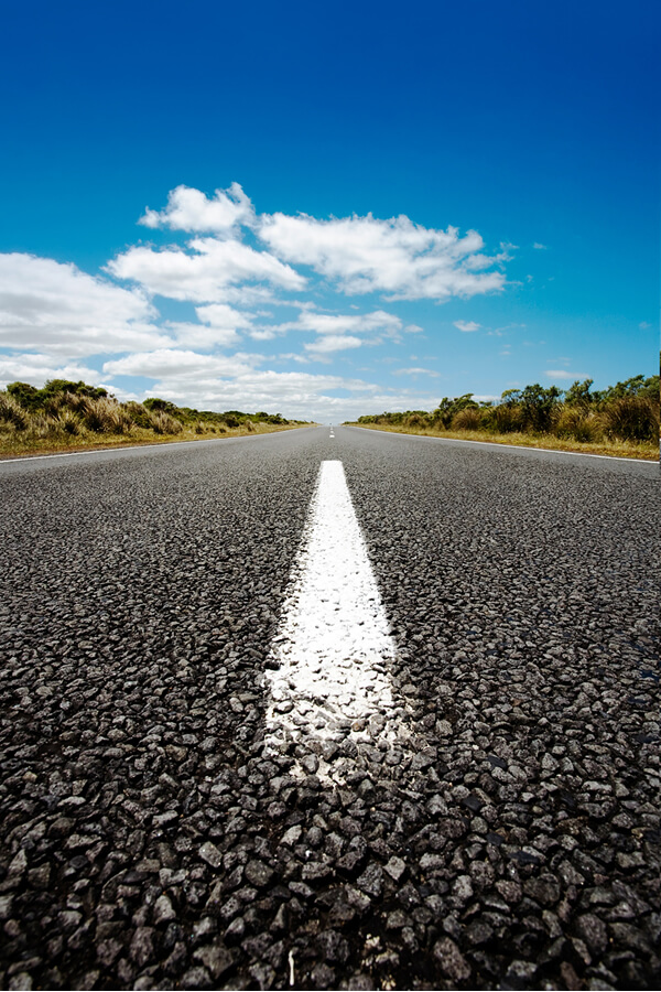 foto-vertical-de-uma-estrada-de-asfalto-sob-o-ceu-azul