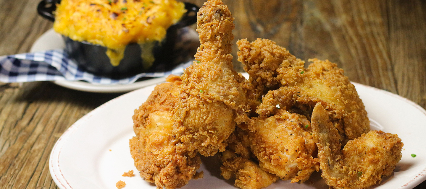 A plate of fried chicken and a mini casserole dish of mac and cheese