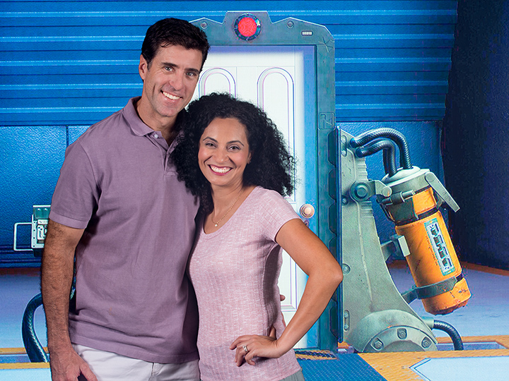 A couple stands in front of a futuristic backdrop