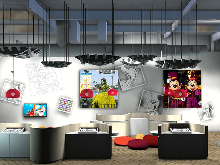 A modern interior features workspaces with monitors, cushions for seating and Disney themed artwork along the walls