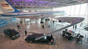 Plain, squad care, and two limos inside a wide open building