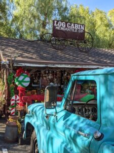 Log cabin with old teal pickup parked out front