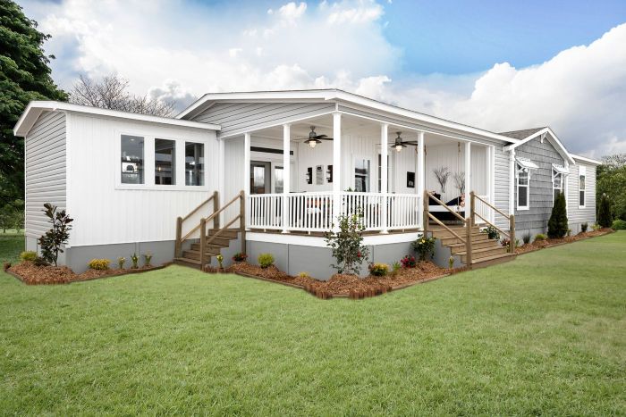 Modern manufactured home exterior with landscaped yard in senior community