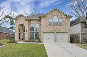 A two-story brick home with a classic suburban design in Auburn Lakes community in Spring, Texas