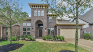 A two-story brick home featuring large arched windows at the Summerwood in Houston Texas