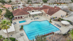 Aerial view of a community pool and clubhouse at Bellavita at Green Tee