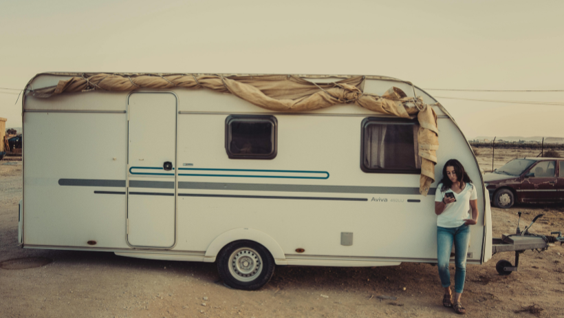 Woman leaning on RV trailer.