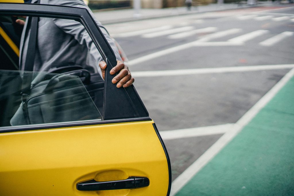 Black man opening door of yellow car