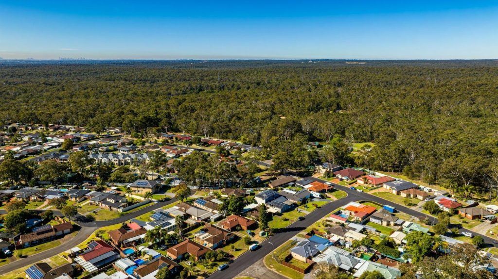 aerial view of a suburban neighborhood surrounded by a dense forest