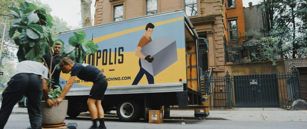 The truck has a yellow and blue design with an illustration of a person carrying a box.