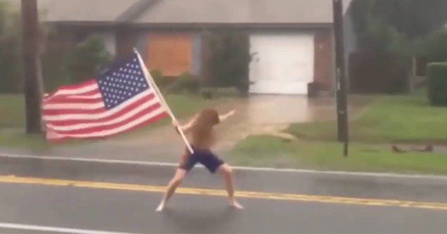 American holding the flag in the middle of a storm