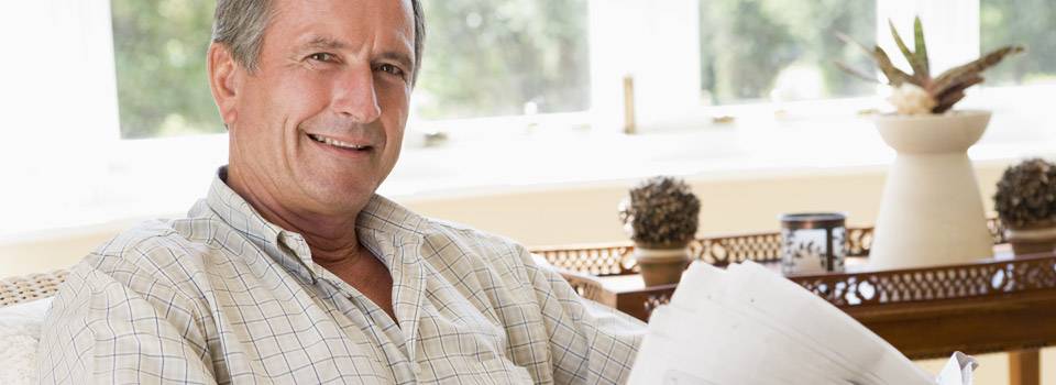 A senior sitting and reading newspaper, Optometrist in Lancaster, OH