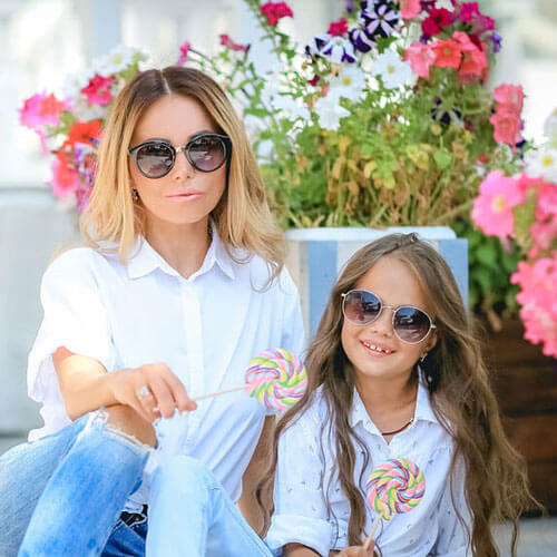 smiling mother and daughter wearing sunglasses