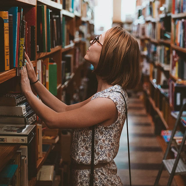 College student wearing eyeglasses, in library