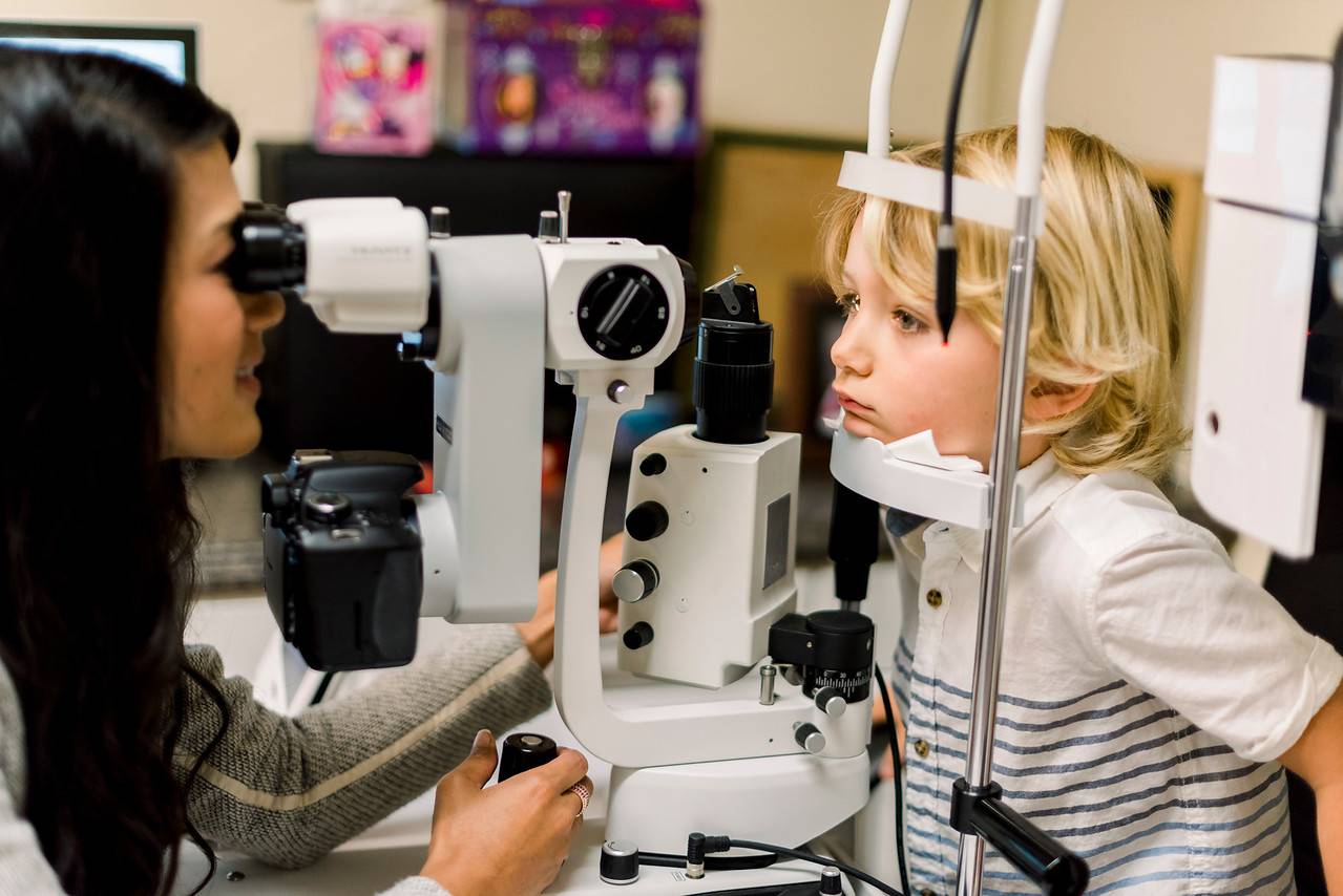 doctor examining young patient with slit lamp