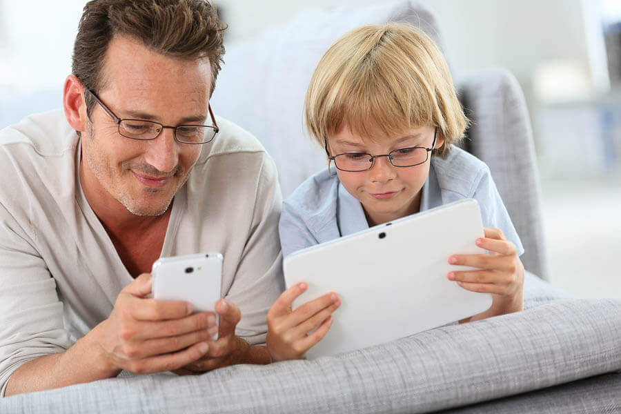 Father and son playing with tablet and smartphone