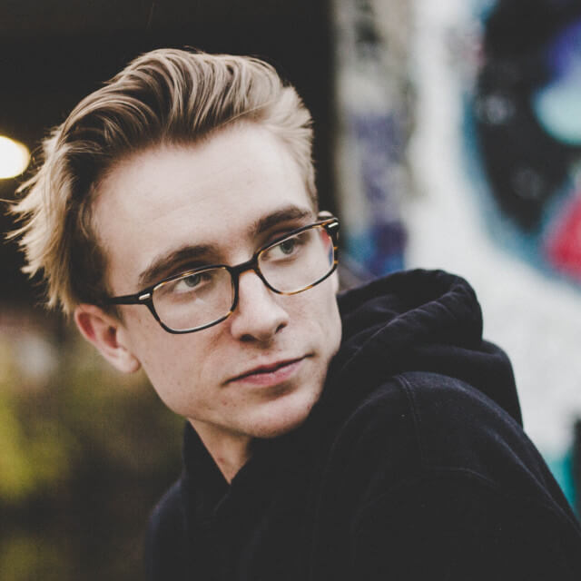 man-wearing-glasses-looking-over-his-shoulder-640