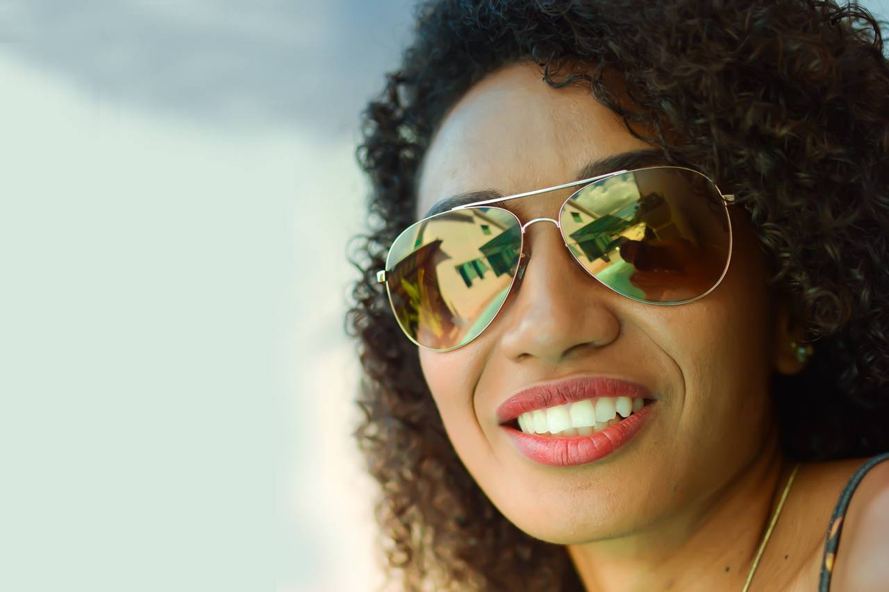 Woman-Smiling-Sunglasses-Sky-1280x853