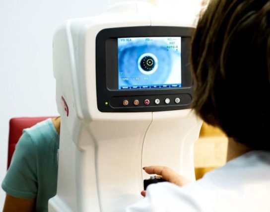 Optician Doctor Working With The Refractometer Machine. Eye Exam