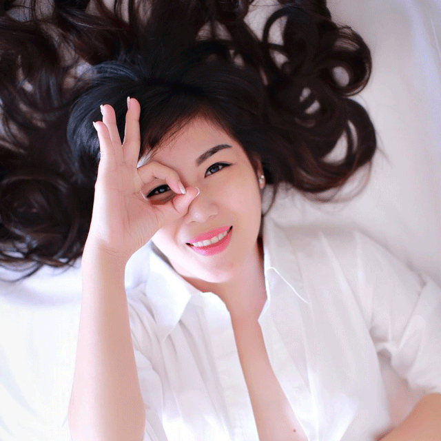 aisian lady with finger circling eye smiling e153139594