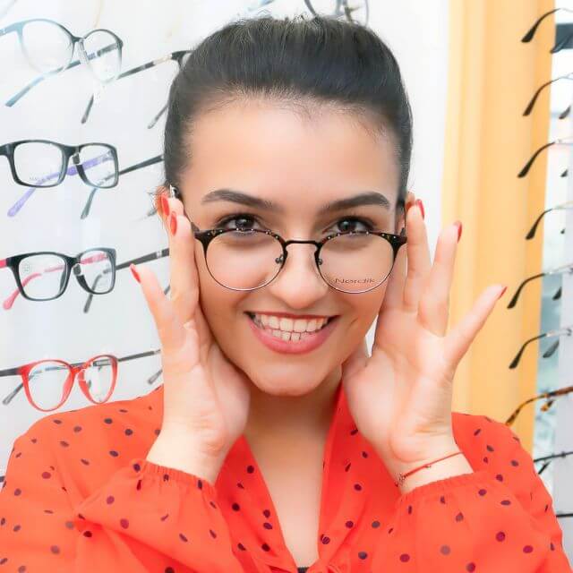 woman smiling trying on glasses