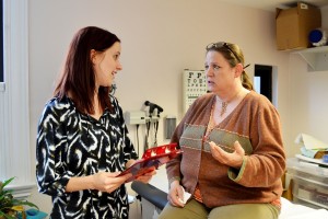 A counselor talks with a client in a medical office.