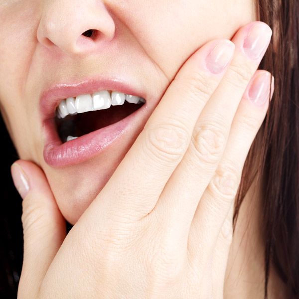 Woman holding jaw in pain