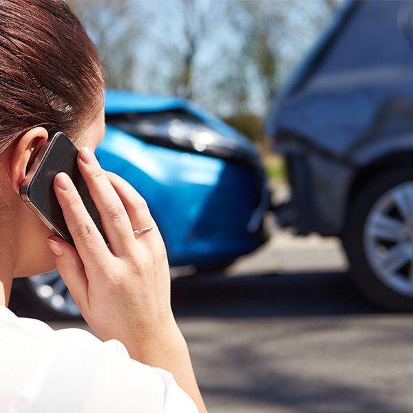 Woman on phone in front of tow truck