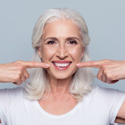 Senior woman pointing to smile