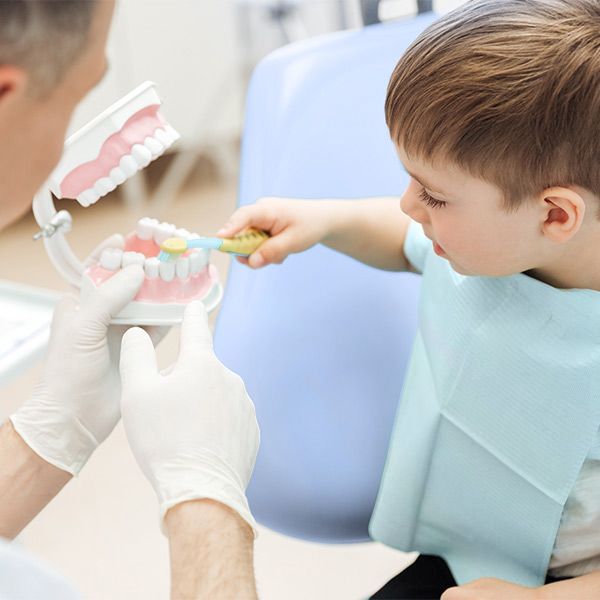 Boy brushing model of teeth