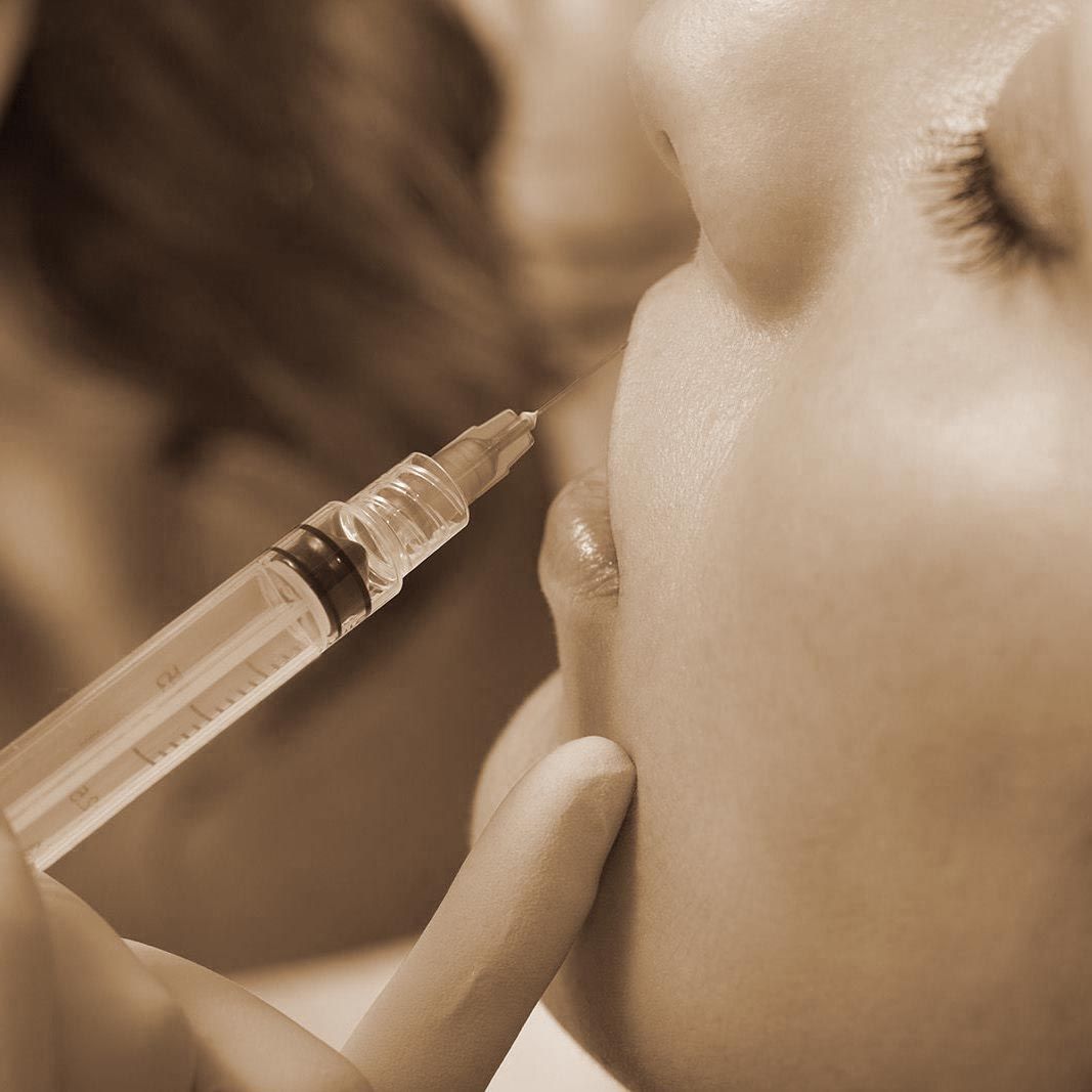 Tip of syringe resting on woman's upper lip
