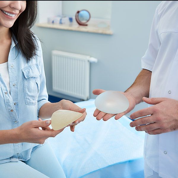 Woman and doctor holding breast implants