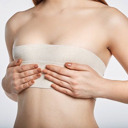 Woman holding bandaged breasts