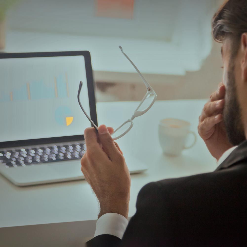Man in front of laptop rubbing eyes